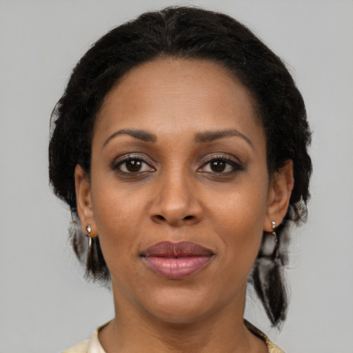 Joyful black adult female with medium  brown hair and brown eyes
