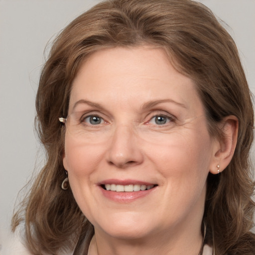 Joyful white adult female with medium  brown hair and grey eyes