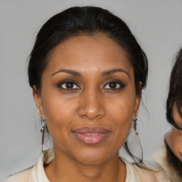 Joyful black adult female with medium  brown hair and brown eyes