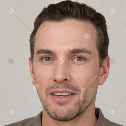 Joyful white young-adult male with short  brown hair and grey eyes