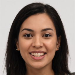 Joyful latino young-adult female with long  brown hair and brown eyes