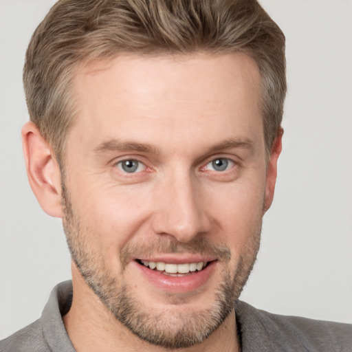 Joyful white adult male with short  brown hair and grey eyes