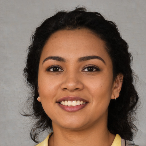 Joyful latino young-adult female with medium  black hair and brown eyes