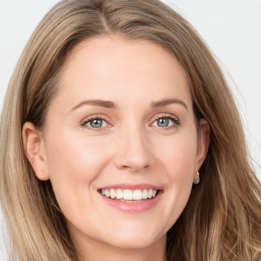 Joyful white young-adult female with long  brown hair and grey eyes