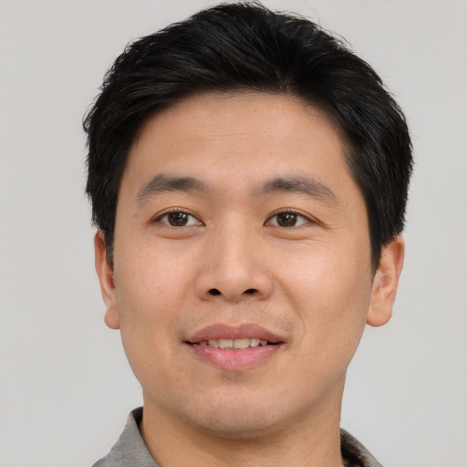Joyful asian young-adult male with short  brown hair and brown eyes