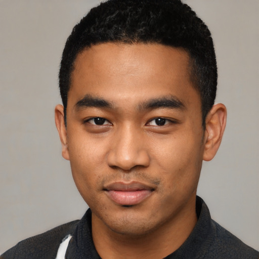 Joyful black young-adult male with short  black hair and brown eyes