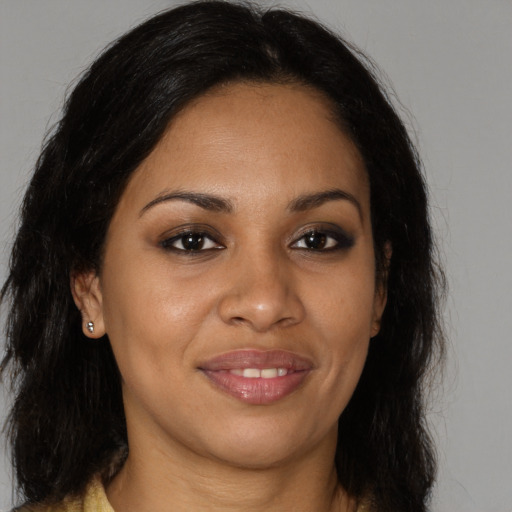 Joyful black young-adult female with long  brown hair and brown eyes
