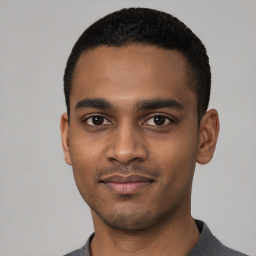 Joyful black young-adult male with short  black hair and brown eyes