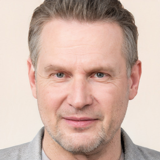 Joyful white adult male with short  brown hair and grey eyes