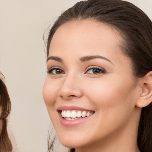 Joyful white young-adult female with long  brown hair and brown eyes