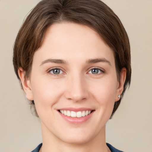 Joyful white young-adult female with medium  brown hair and grey eyes