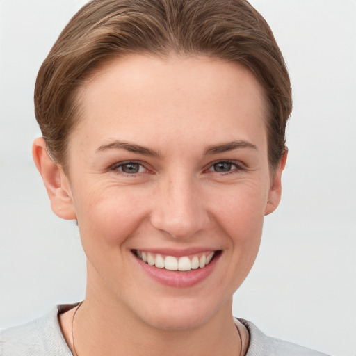 Joyful white young-adult female with short  brown hair and grey eyes