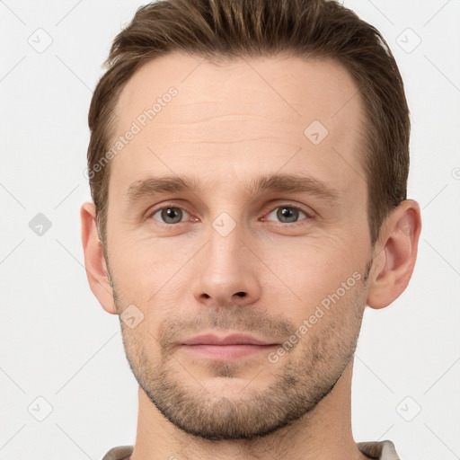 Joyful white young-adult male with short  brown hair and grey eyes