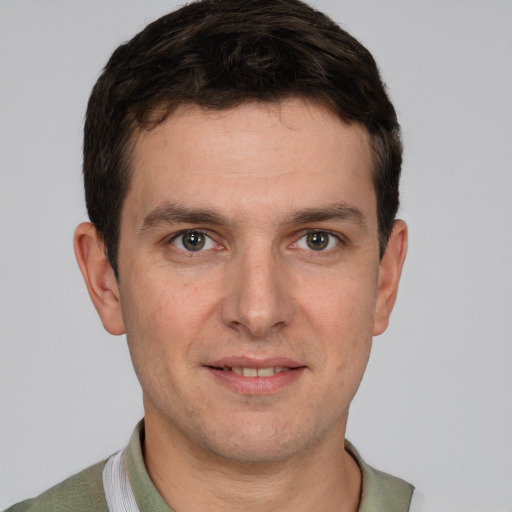 Joyful white young-adult male with short  brown hair and grey eyes