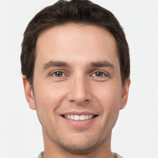 Joyful white young-adult male with short  brown hair and grey eyes