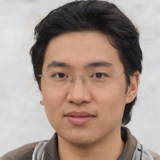 Joyful asian young-adult male with short  brown hair and brown eyes