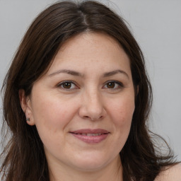 Joyful white adult female with long  brown hair and brown eyes