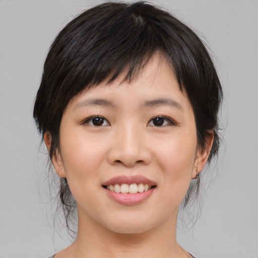 Joyful asian young-adult female with medium  brown hair and brown eyes
