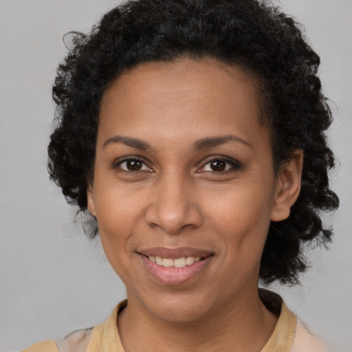 Joyful black adult female with short  brown hair and brown eyes