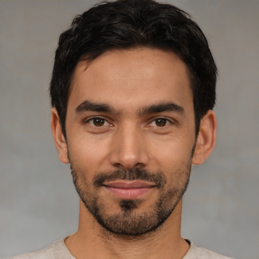 Joyful latino young-adult male with short  black hair and brown eyes