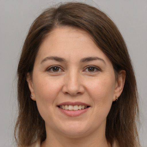 Joyful white adult female with long  brown hair and brown eyes