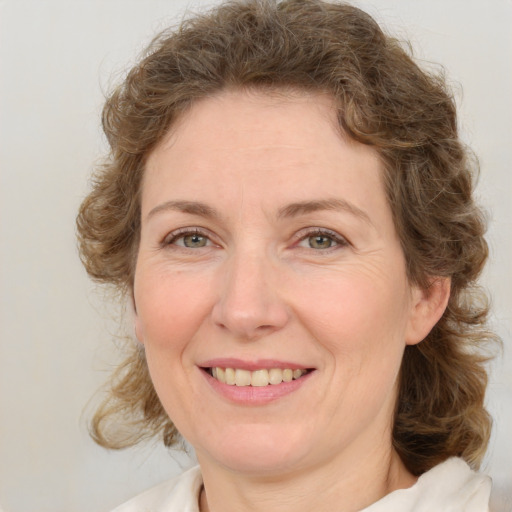 Joyful white adult female with medium  brown hair and green eyes