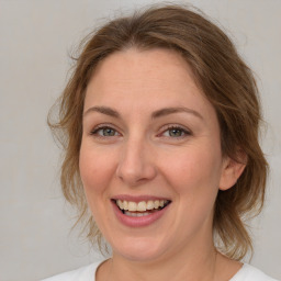 Joyful white young-adult female with medium  brown hair and green eyes