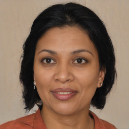 Joyful latino adult female with medium  brown hair and brown eyes