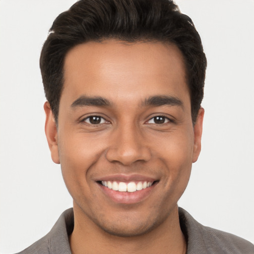 Joyful latino young-adult male with short  brown hair and brown eyes