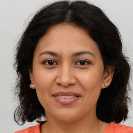 Joyful latino adult female with medium  brown hair and brown eyes