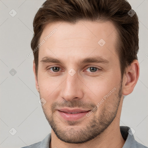 Joyful white young-adult male with short  brown hair and grey eyes