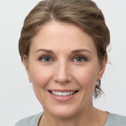 Joyful white adult female with medium  brown hair and grey eyes