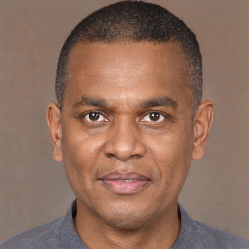 Joyful black adult male with short  brown hair and brown eyes
