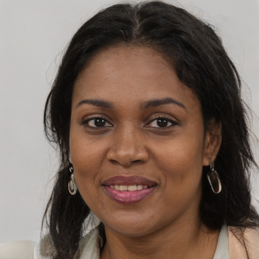 Joyful black young-adult female with long  brown hair and brown eyes