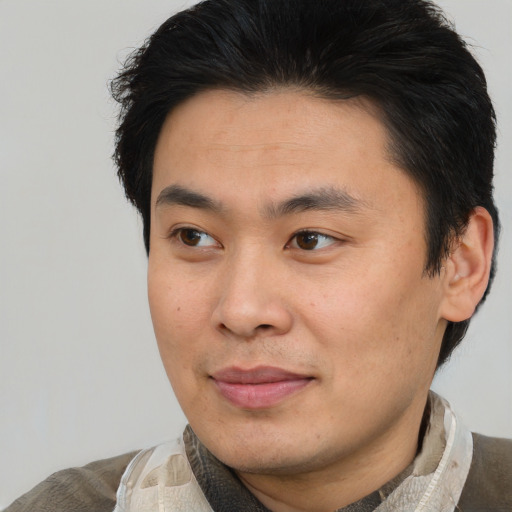 Joyful asian young-adult male with short  brown hair and brown eyes