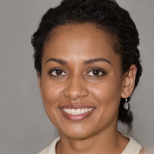 Joyful black young-adult female with short  brown hair and brown eyes