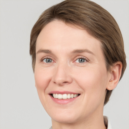 Joyful white young-adult female with short  brown hair and grey eyes