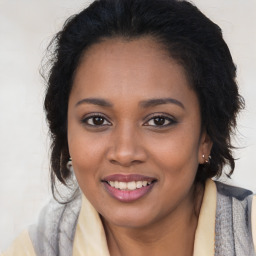 Joyful black young-adult female with long  brown hair and brown eyes