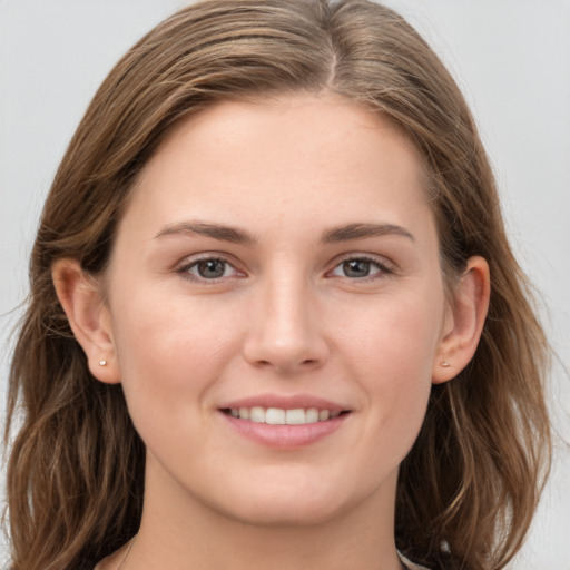 Joyful white young-adult female with long  brown hair and grey eyes