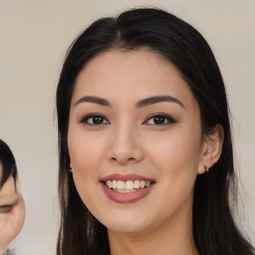 Joyful asian young-adult female with long  black hair and brown eyes