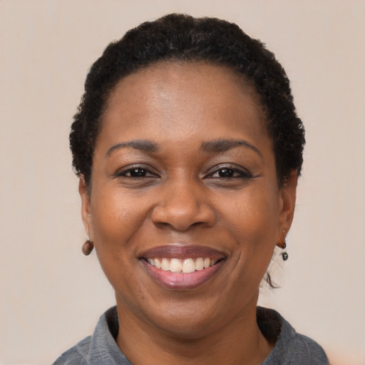 Joyful black adult female with short  black hair and brown eyes