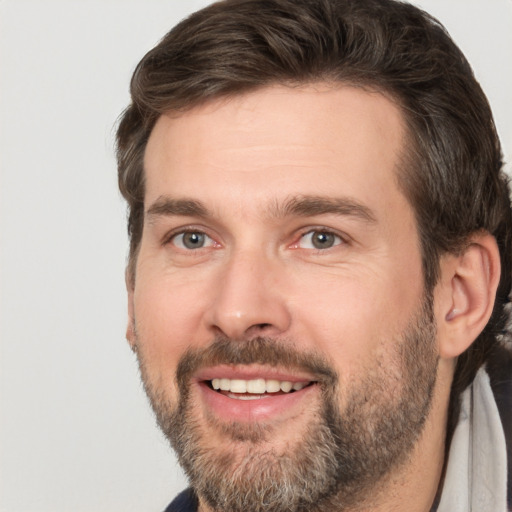 Joyful white adult male with short  brown hair and brown eyes