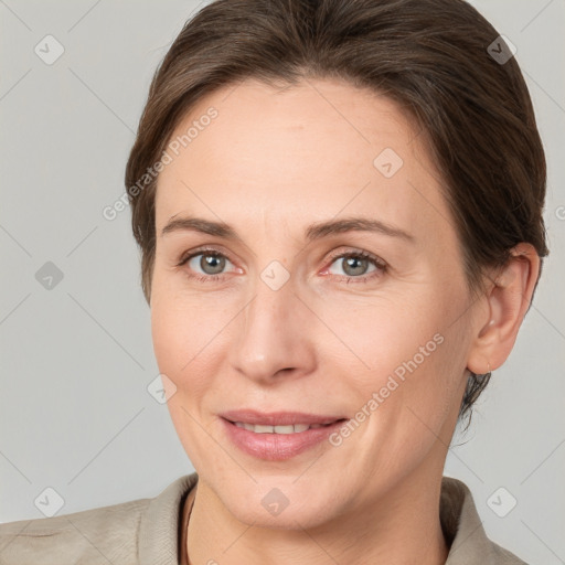 Joyful white adult female with medium  brown hair and grey eyes