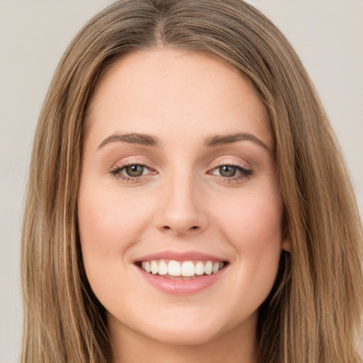 Joyful white young-adult female with long  brown hair and green eyes