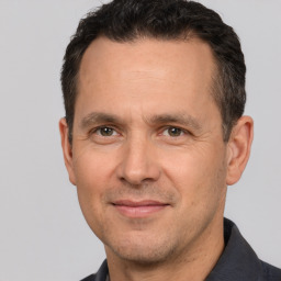 Joyful white adult male with short  brown hair and brown eyes
