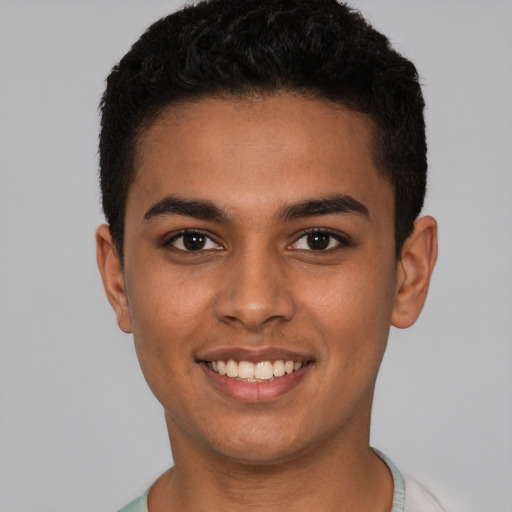 Joyful latino young-adult male with short  brown hair and brown eyes