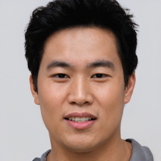 Joyful asian young-adult male with short  black hair and brown eyes
