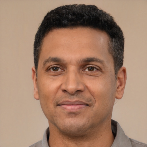 Joyful latino adult male with short  black hair and brown eyes