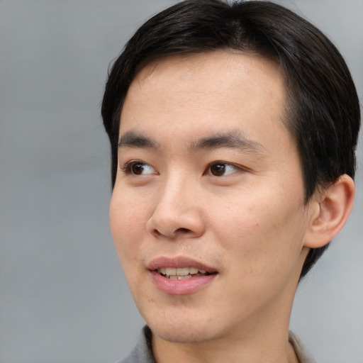 Joyful asian young-adult male with short  brown hair and brown eyes