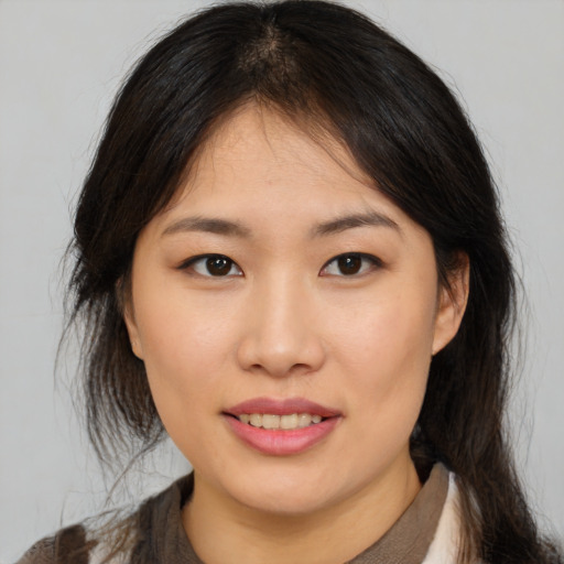 Joyful asian young-adult female with medium  brown hair and brown eyes